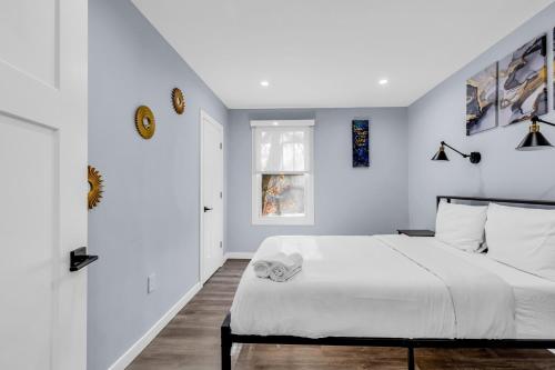 a white bedroom with a bed and a window at Luxury 3BR House in Charlotte in Charlotte