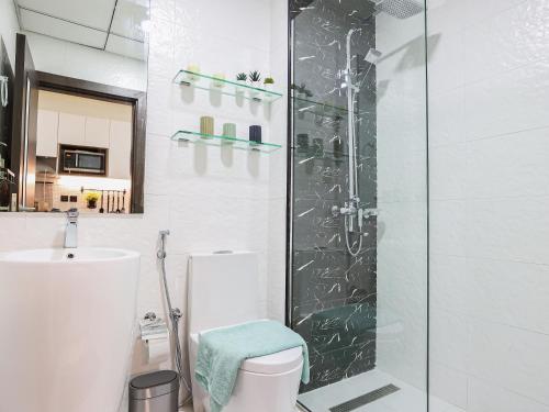 a bathroom with a shower and a toilet and a sink at Elite LUX Holiday Homes - Modern Studio in Arjan, Dubai in Dubai