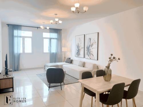 Elite LUX Holiday Homes - Two Bedroom Apartment Metro Nearby in Al Furjan, Dubai في دبي: غرفة معيشة مع أريكة وطاولة