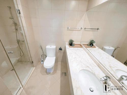 La salle de bains est pourvue de toilettes, d'un lavabo et d'une douche. dans l'établissement Elite LUX Holiday Homes - Two Bedroom Apartment Metro Nearby in Al Furjan, Dubai, à Dubaï