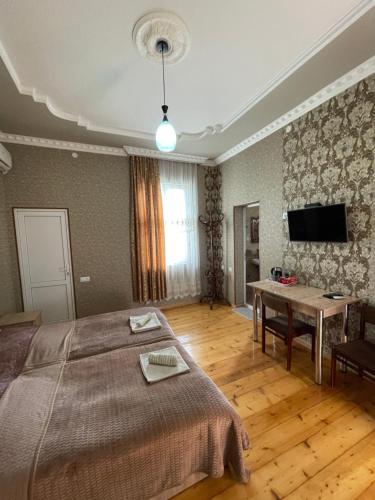 Dormitorio con cama, escritorio y TV en Elco en Zugdidi