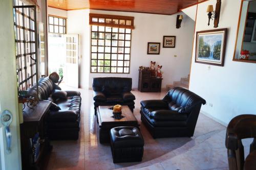 uma sala de estar com sofás de couro e uma mesa de centro em Casa Campestre El Rosal em Santana