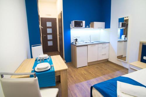 Habitación con paredes azules, mesa y sillas. en Focus Point Apartments, en Budapest