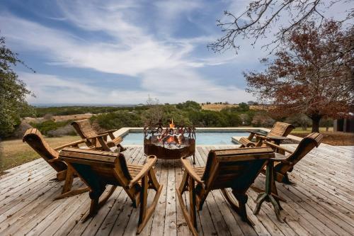 a wooden deck with a table and chairs and a pool at Rockin' 7 in Glen Rose