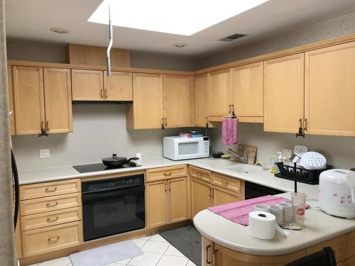 a kitchen with wooden cabinets and a stove top oven at Super bedroom with private bathroom 5 in Las Vegas