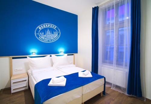 Cama en habitación con pared azul en Focus Point Apartments, en Budapest