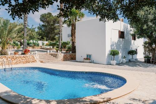 a swimming pool in front of a white house at Can Pep Gibert in Ibiza Town