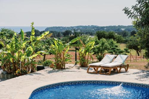 a swimming pool with two lounge chairs next to at Can Pep Gibert in Ibiza Town