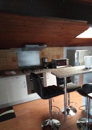 - une cuisine avec un comptoir et quelques chaises dans l'établissement Appartement dans villa Saint Jean de Luz, à Saint-Jean-de-Luz