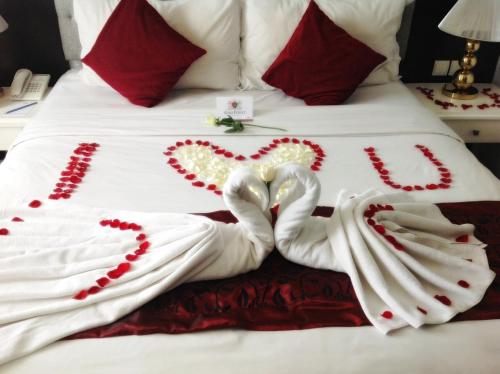 two swans made out of towels on a bed at Gino Feruci Braga by KAGUM Hotels in Bandung