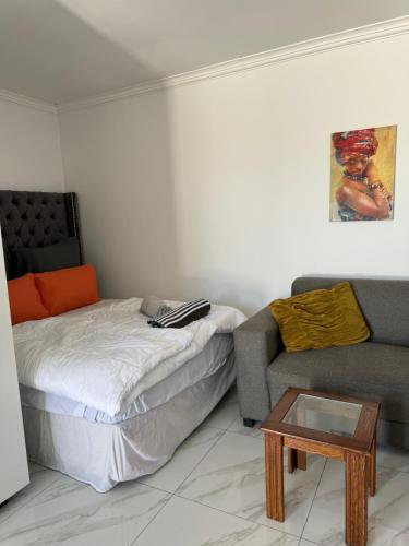 sala de estar con cama y sofá en Mila Lodge 2, en Ciudad del Cabo