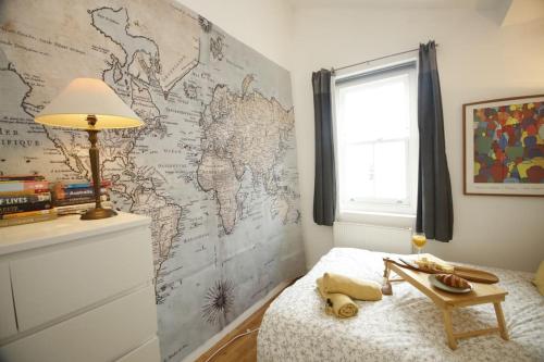 a bedroom with a map of the world on the wall at Very Nice Flat close to Camden Station in London
