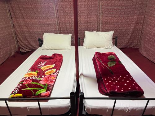 ein Bett in einem Zelt mit zwei Kissen darauf in der Unterkunft SandGlass Camp in Badīyah