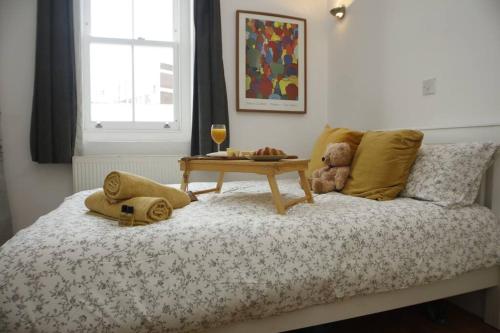 a bedroom with a bed with a table on it at Very Nice Flat close to Camden Station in London