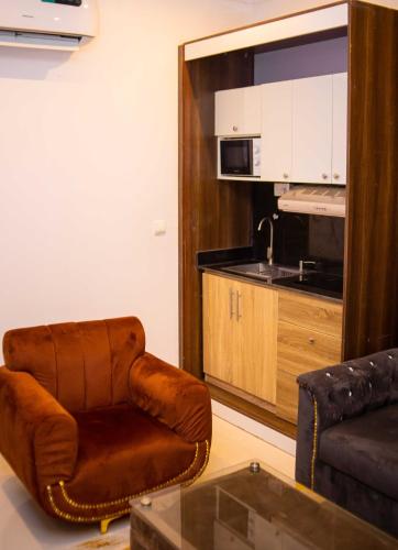 a living room with a brown chair and a couch at Dozubel Hotel in Abuja