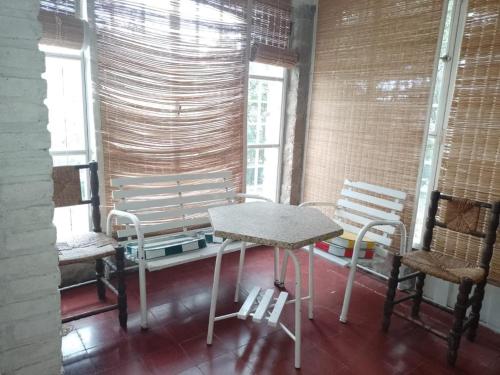 una mesa y sillas en una habitación con ventanas en Chalet ,cuesta blanca en Villa Icho Cruz