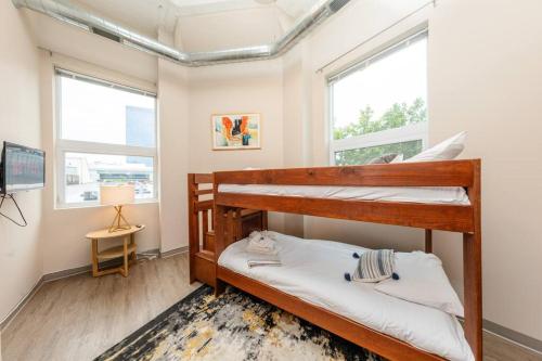 two bunk beds in a room with two windows at McCormick 2br/2ba Oasis with Optional Parking, Patio, Gym for up to 6 guests in Chicago