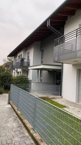 a white building with a fence in front of it at Appartamento Nord Udine in Feletto Umberto