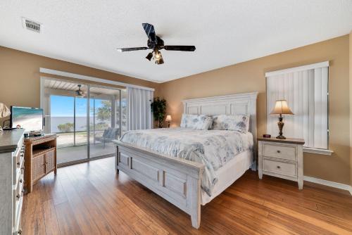 Un dormitorio con una cama y un ventilador de techo. en Bay Dreamin, en Gulf Highlands