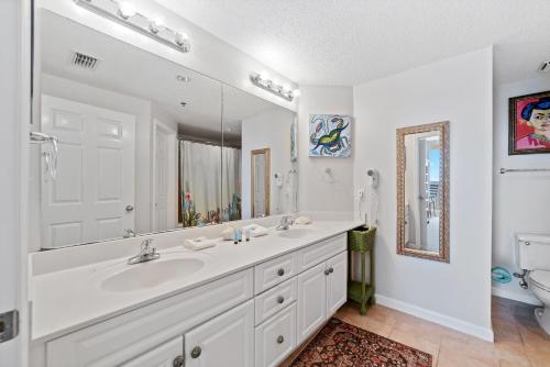 a white bathroom with a sink and a mirror at Beach Club Avalon 1204 in Gulf Highlands