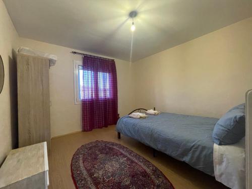 - une chambre avec un lit, une fenêtre et un tapis dans l'établissement Μονοκατοικια 3 δωματιων, à Kateríni
