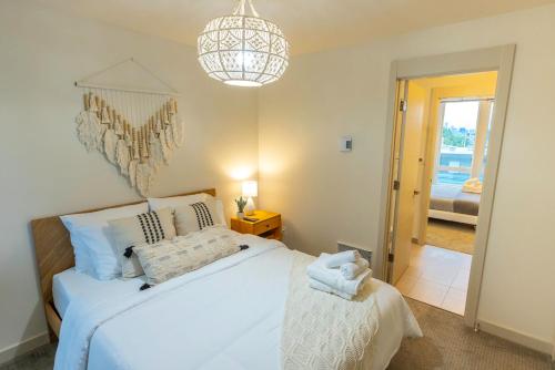 ein Schlafzimmer mit einem weißen Bett und einem Kronleuchter in der Unterkunft 47th Elegance BY Betterstay in Seattle