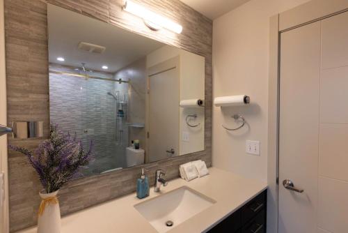 a bathroom with a sink and a large mirror at 47th Elegance BY Betterstay in Seattle