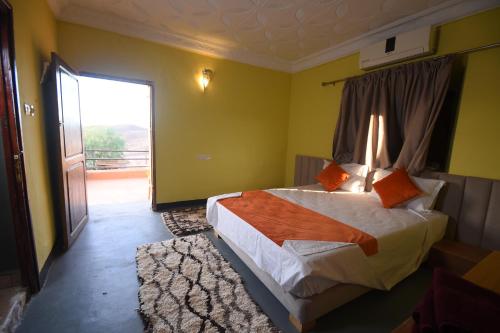 a bedroom with a bed and a sliding glass door at Kasbah Tifoultoute in Ouarzazate