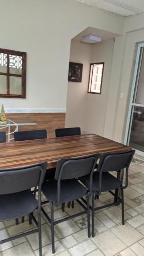 a dining room with a wooden table and chairs at Casa de praia in Guarapari