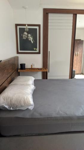 sypialnia z dużym łóżkiem z drewnianym zagłówkiem w obiekcie Casa de praia w mieście Guarapari