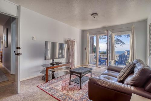 a living room with a couch and a television at Just Beachy 101 in Yachats