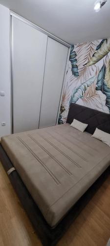 uma cama grande num quarto com uma parede em Finans1 em Ruma