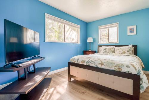 a bedroom with blue walls and a bed and a desk at Just Beachy 101 in Yachats