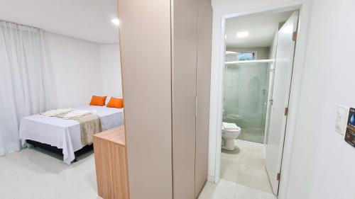 biała sypialnia z łóżkiem i toaletą w obiekcie Sunset by AFT - PORTO DE GALINHAS w mieście Porto de Galinhas