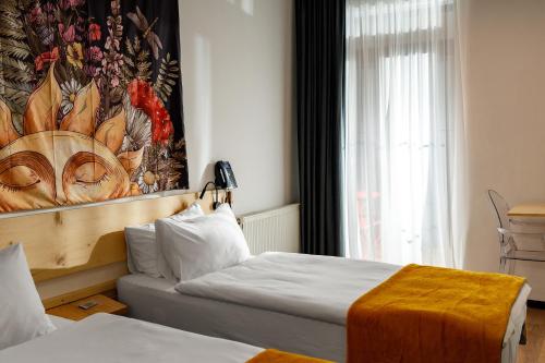 a hotel room with two beds and a painting on the wall at Hydeout Bakuriani in Bakuriani