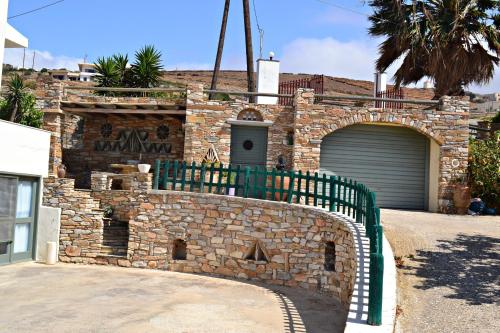 a stone building with a gate and a garage at Stelios Zalonis Apartments in Tinos Town