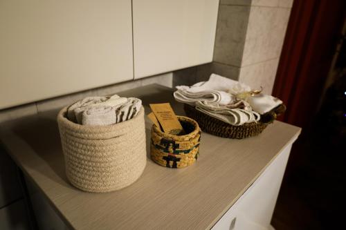 three baskets of towels on a counter in a bathroom at I Rosai appartamento sulle colline fiorentine in Bagno a Ripoli
