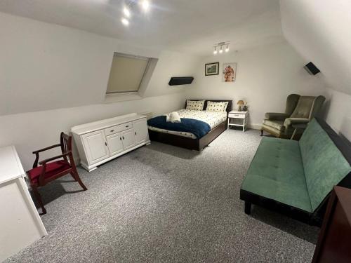 ein Schlafzimmer mit einem Bett, einem Sofa und einem Stuhl in der Unterkunft Large 3 bedroom house in Nottingham