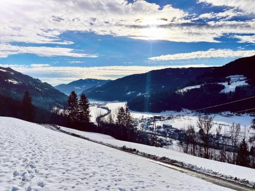 a snow covered mountain with the sun in the background at Lärchenhaus ,,Unterer Brodl" in Kammersberg
