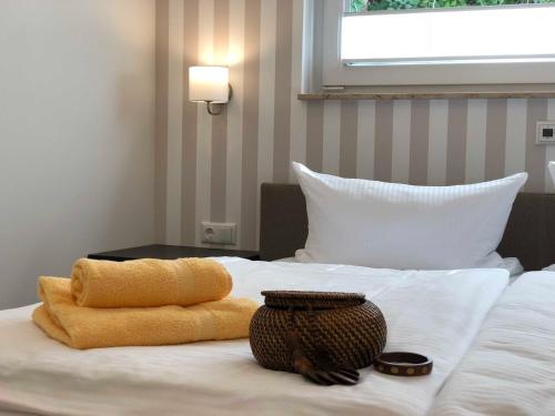 a bed with two towels and a basket on it at Luxus Ferienhaus - Kleine Rosenvilla in Sassnitz