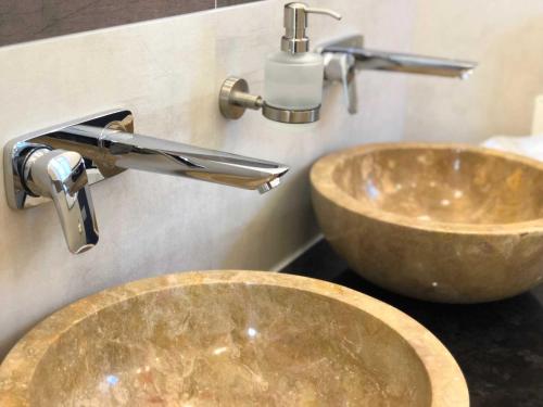 a bathroom with two sinks and a faucet at Luxus Ferienhaus - Kleine Rosenvilla in Sassnitz