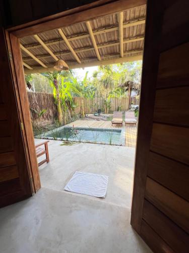 una puerta abierta a un patio con piscina en Villa Sagui Trancoso en Trancoso