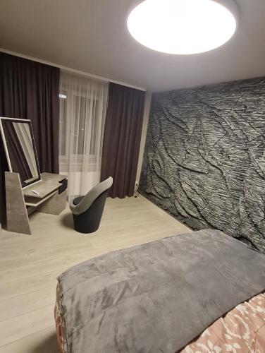 a bedroom with a bed and a desk and a chair at ALISE in Ludza