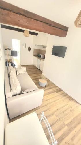 - un salon avec un canapé blanc et du parquet dans l'établissement Studio centre historique Mauguio, à Mauguio