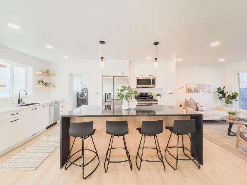 a kitchen with a large island in a kitchen with bar stools at Ultra-modern Home in the Perfect Location in Millcreek