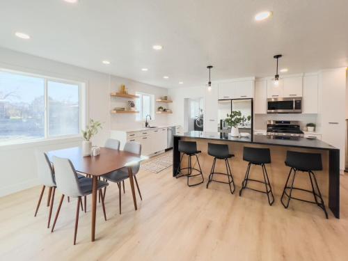 a kitchen with a wooden table and chairs and a counter at Ultra-modern Home in the Perfect Location in Millcreek