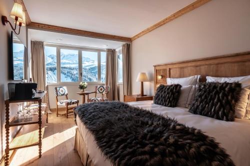 a bedroom with a large bed with a large window at Alpes Hôtel du Pralong in Courchevel