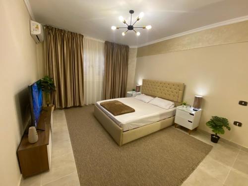 a bedroom with a bed and a flat screen tv at Charming 2BR with Private Garden in Cairo