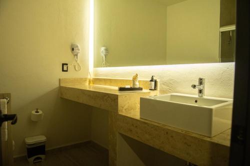 bagno con lavandino e specchio di HOTEL MERLOT INN a Ezequiel Montes