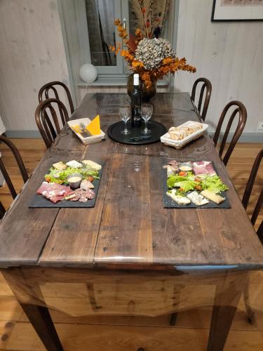 聖薩蒂南的住宿－Chambres d'hôtes du Bistrot d'ici，一张木桌,上面有三盘食物